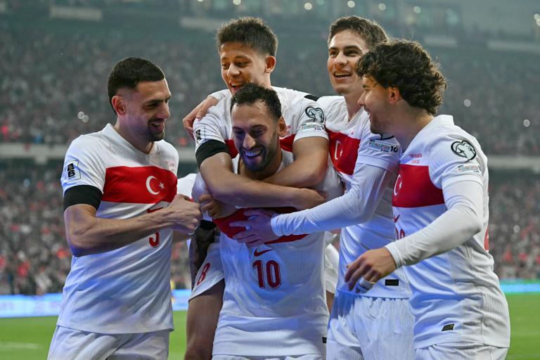 Turkey's midfielder #10 Hakan Calhanoglu (C) is congratulated by teammates after scoring a penalty during the FIFA World Cup 2026 European qualification football match between Turkey and Bulgaria at the Timsah Arena stadium, in Bursa, on November 15, 2025. (Photo by OZAN KOSE / AFP) (Photo by OZAN KOSE/AFP via Getty Images)          